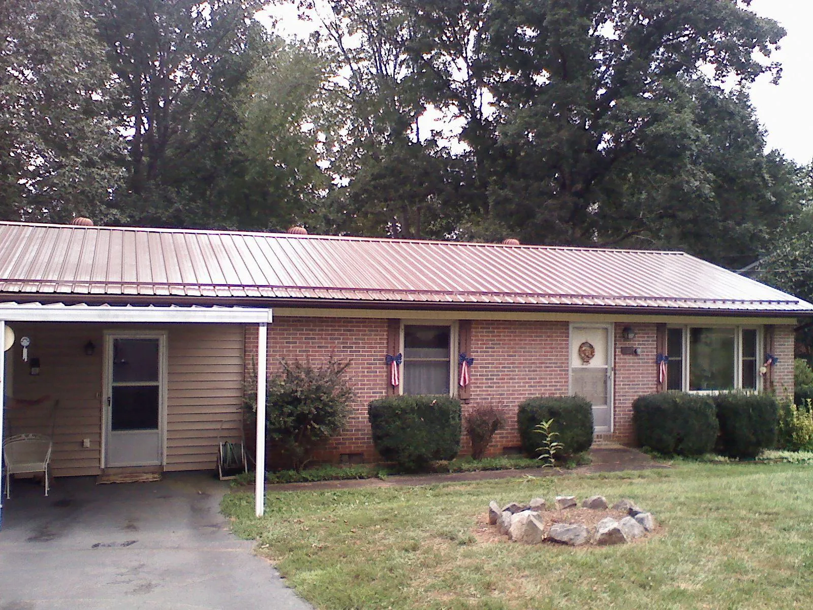 Bronze metal roof and carport on a brick ranch home — Roof Repair work by our crew in Reubens